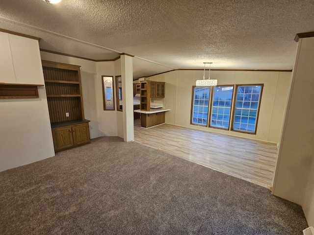 unfurnished living room featuring a textured ceiling, carpet, crown molding, and vaulted ceiling