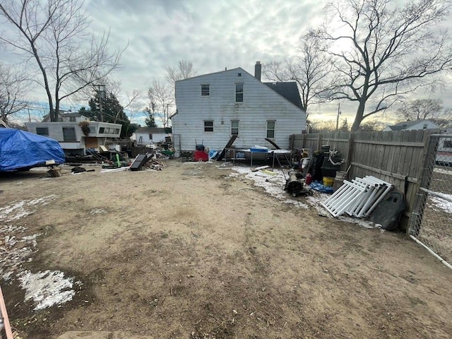 back of property featuring a chimney and fence