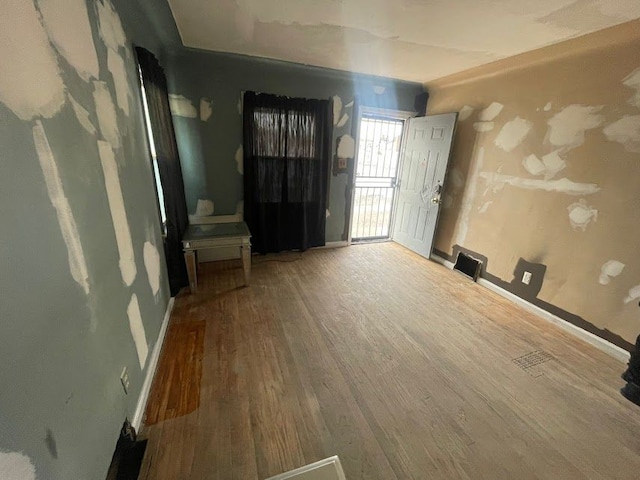 interior space featuring visible vents, baseboards, and wood finished floors