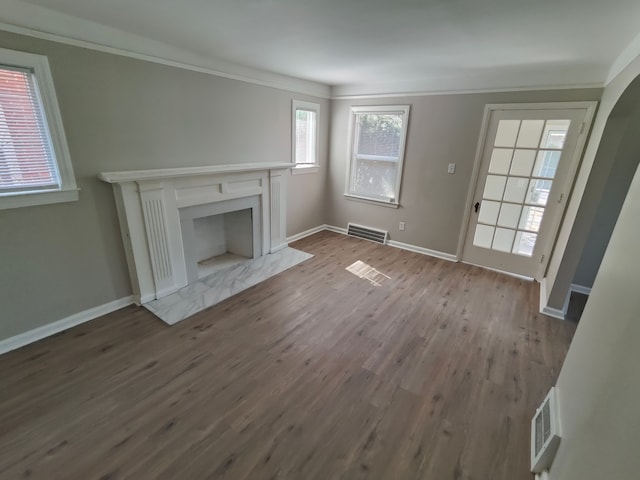 unfurnished living room featuring baseboards, wood finished floors, visible vents, and a premium fireplace