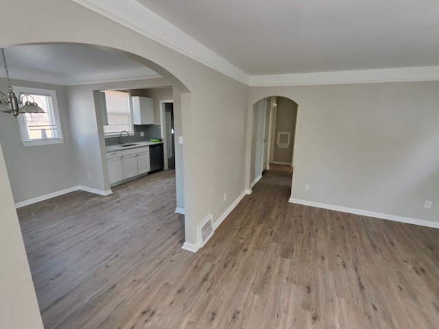 empty room with wood finished floors, visible vents, and baseboards