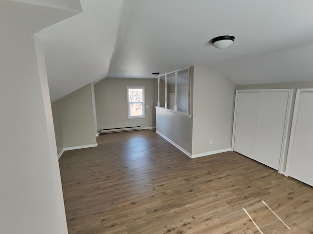 bonus room with baseboards, lofted ceiling, baseboard heating, and wood finished floors