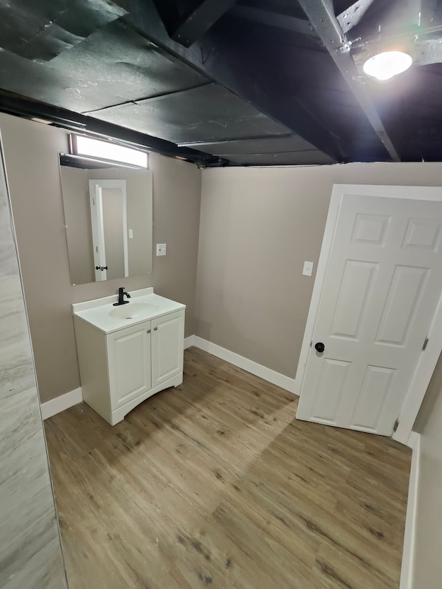 interior space featuring baseboards, light wood-type flooring, and a sink