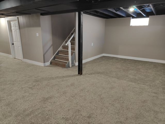 basement featuring stairway, baseboards, and carpet