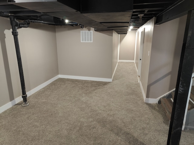 finished basement with visible vents, carpet floors, baseboards, and stairway