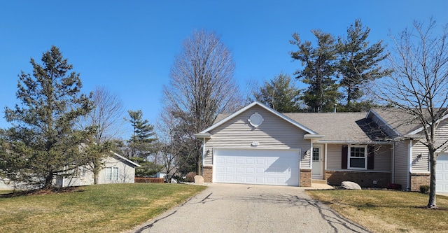 view of front facade featuring a garage, driveway, brick siding, and a front lawn