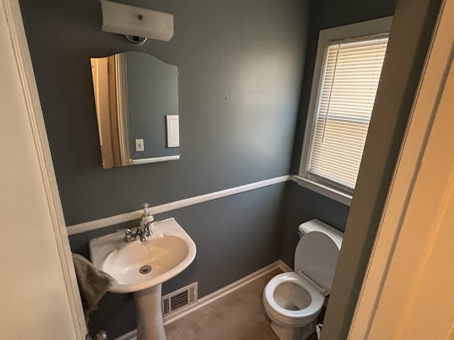 bathroom featuring a sink, visible vents, baseboards, and toilet