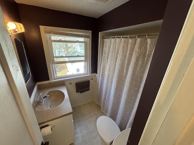 bathroom featuring a shower with shower curtain, toilet, and vanity