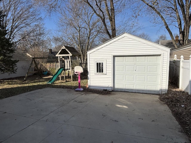 detached garage with concrete driveway and fence