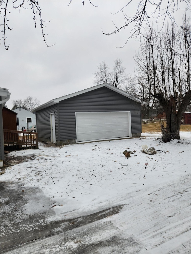 snow covered garage with a detached garage