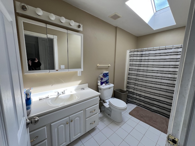 bathroom with visible vents, toilet, a skylight, tile patterned floors, and vanity