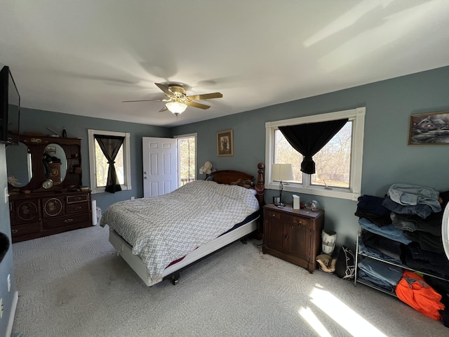 carpeted bedroom featuring multiple windows and ceiling fan