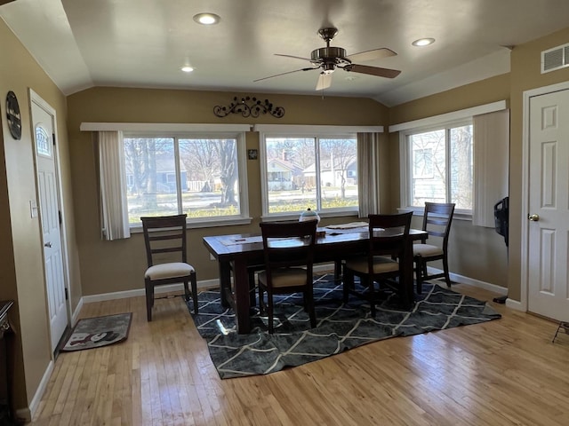 dining space featuring baseboards, light wood-style flooring, a ceiling fan, and lofted ceiling