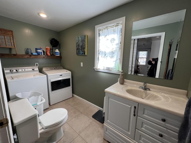 bathroom featuring tile patterned flooring, baseboards, toilet, vanity, and separate washer and dryer