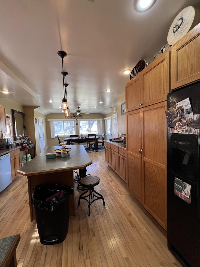 kitchen featuring stainless steel dishwasher, light wood-style floors, freestanding refrigerator, and a kitchen island