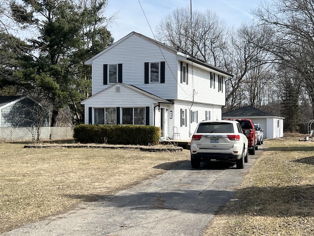 view of front of house with an outdoor structure and fence