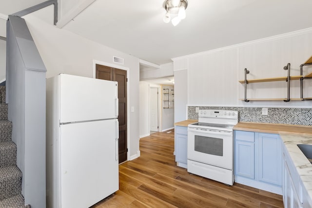 kitchen featuring blue cabinets, visible vents, white appliances, decorative backsplash, and wooden counters