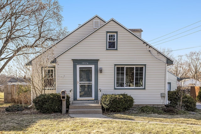 bungalow with a front lawn and fence