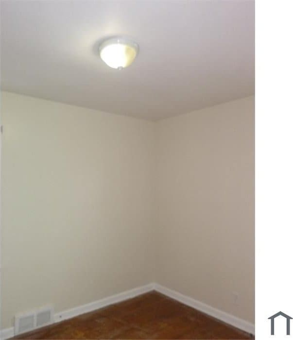 empty room featuring baseboards and visible vents