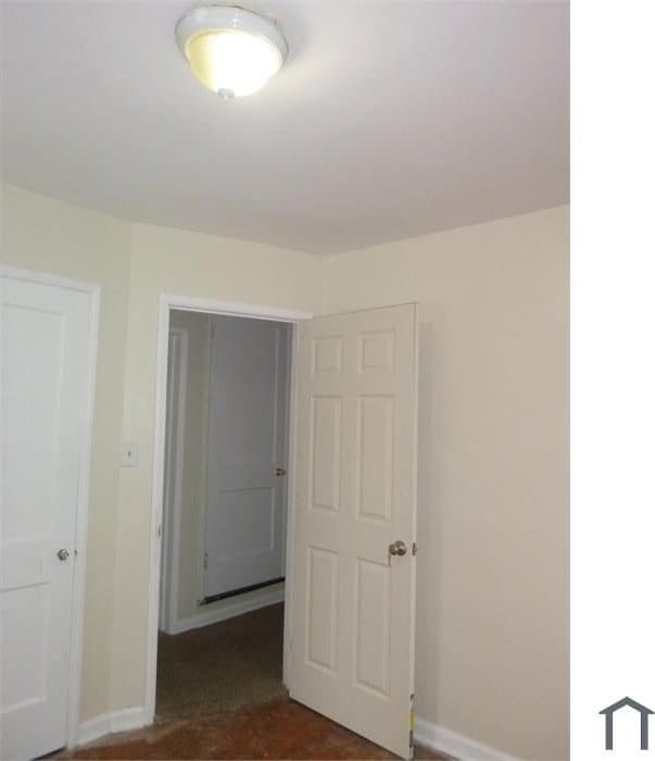 unfurnished room with baseboards