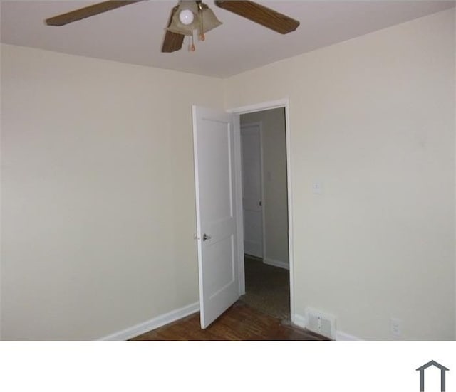 spare room with visible vents, baseboards, dark wood finished floors, and a ceiling fan