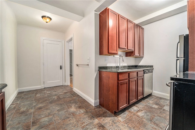 kitchen with freestanding refrigerator, stone finish floor, dishwasher, a sink, and dark countertops