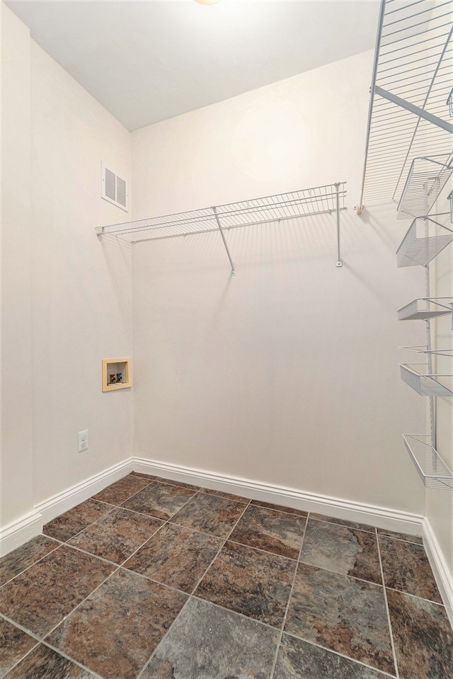 washroom featuring stone finish flooring, laundry area, washer hookup, visible vents, and baseboards