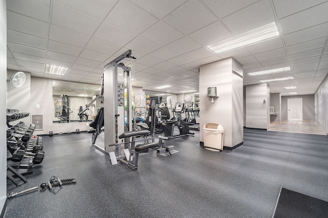 workout area with baseboards and a drop ceiling