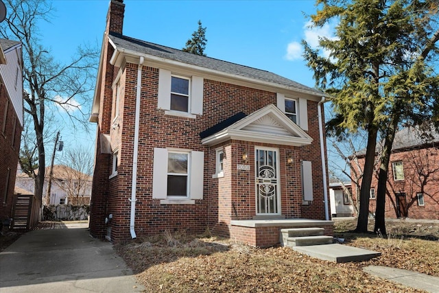 view of front of house featuring brick siding and a chimney