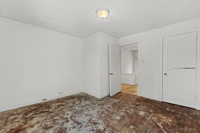 unfurnished bedroom featuring baseboards and a textured ceiling