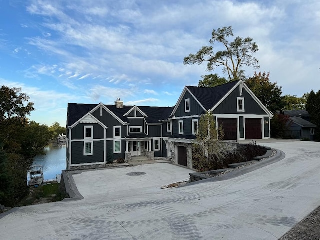 view of front facade with a chimney, board and batten siding, concrete driveway, and an attached garage