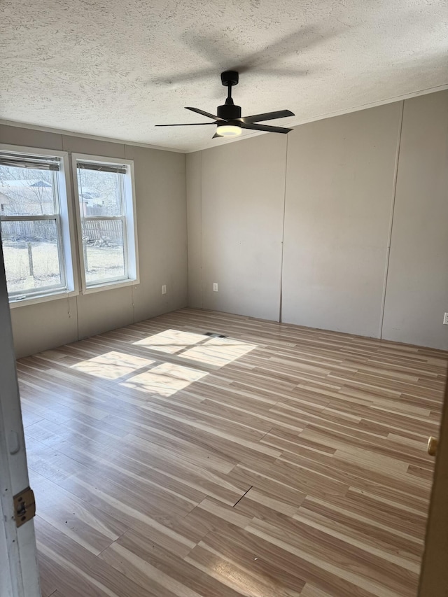 unfurnished room featuring a textured ceiling, wood finished floors, and ceiling fan