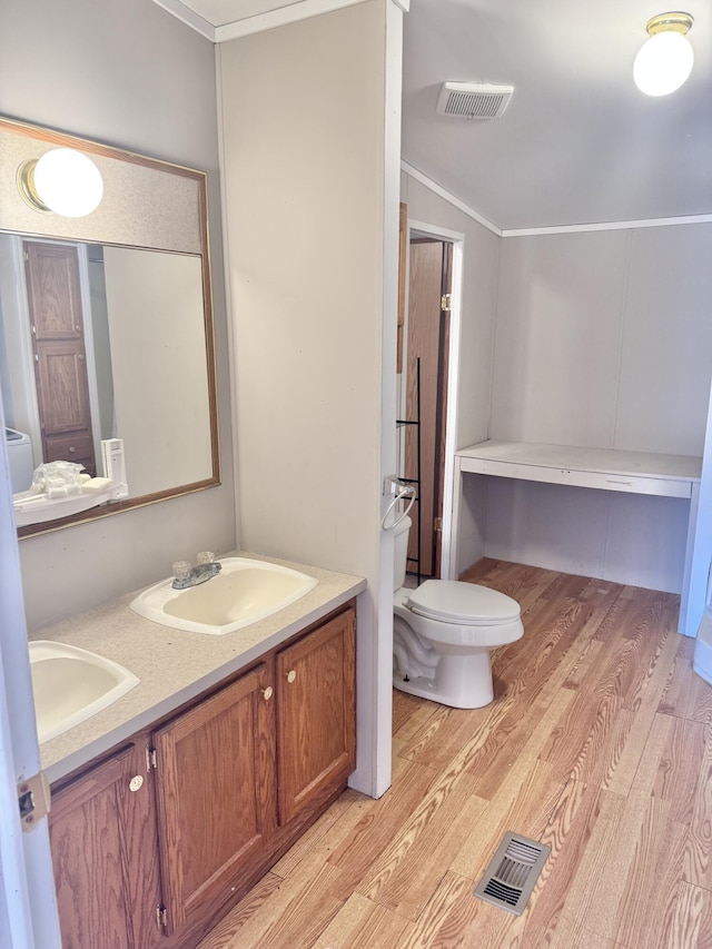 full bathroom with toilet, wood finished floors, visible vents, and a sink