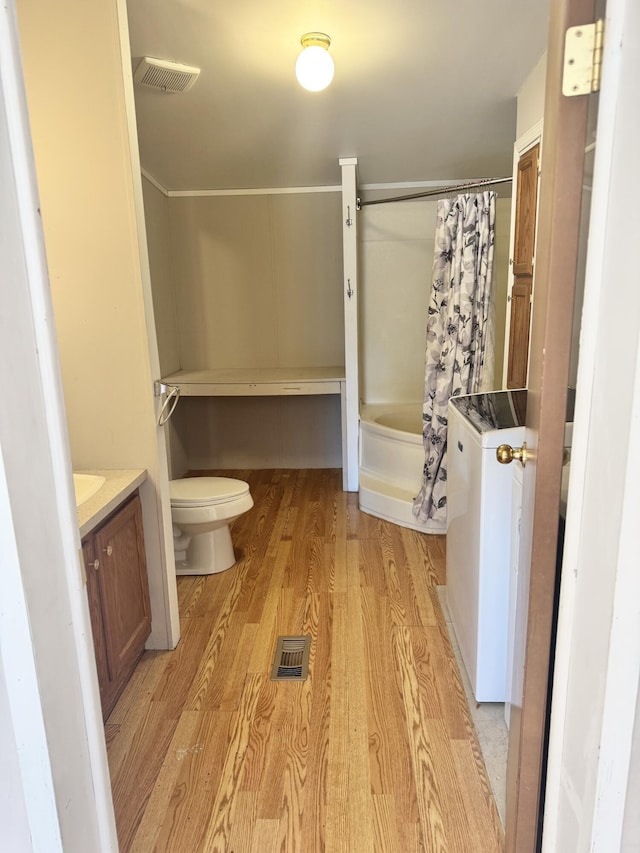 full bathroom with vanity, toilet, wood finished floors, and visible vents