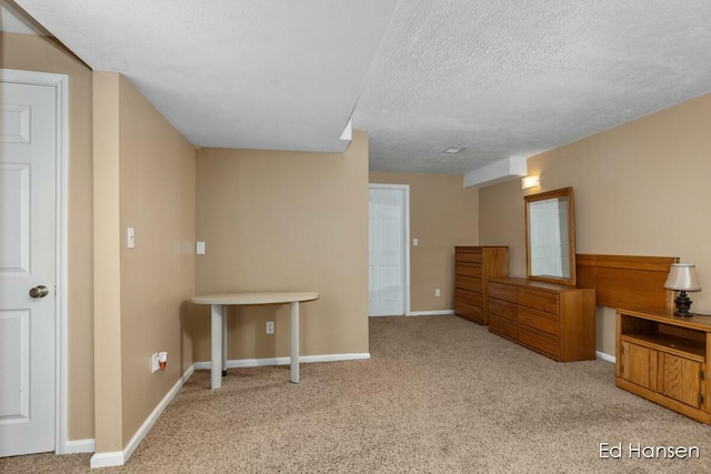 bedroom with baseboards, carpet floors, and a textured ceiling