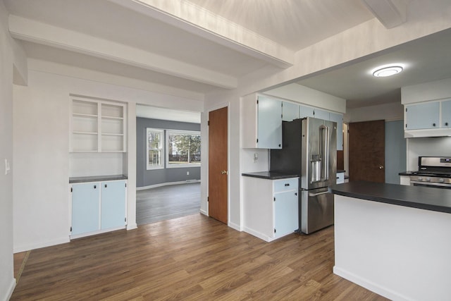 kitchen featuring beam ceiling, dark countertops, dark wood-style floors, stainless steel appliances, and baseboards