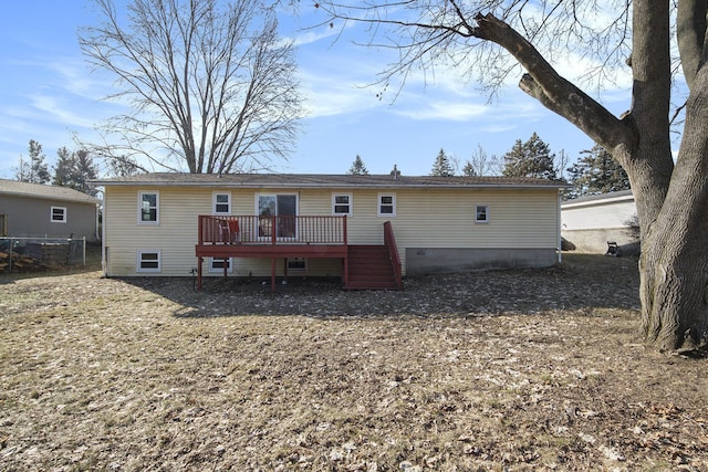 rear view of property featuring a wooden deck and fence