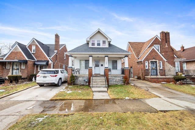 bungalow-style home with covered porch and driveway