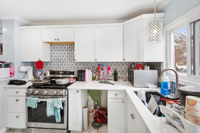 kitchen with tasteful backsplash, white cabinets, and gas stove