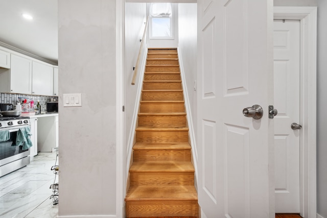 stairway featuring marble finish floor