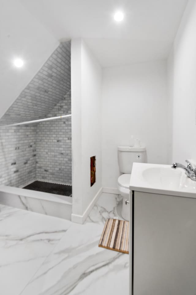 bathroom featuring baseboards, toilet, a stall shower, marble finish floor, and vanity