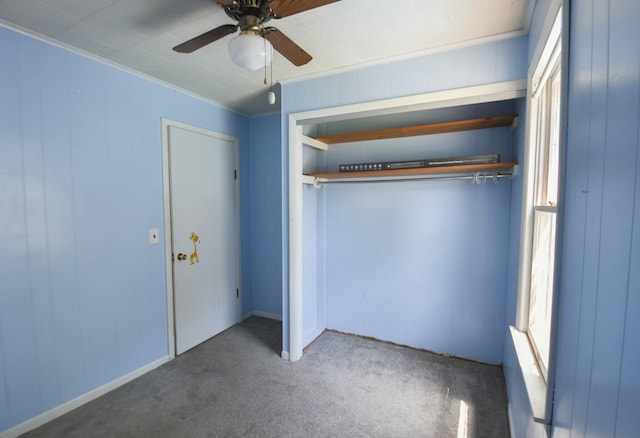 unfurnished bedroom with a closet, a ceiling fan, crown molding, and carpet