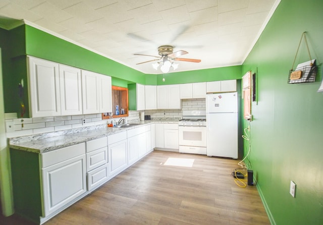 kitchen with a sink, white appliances, light wood-style floors, white cabinets, and ceiling fan