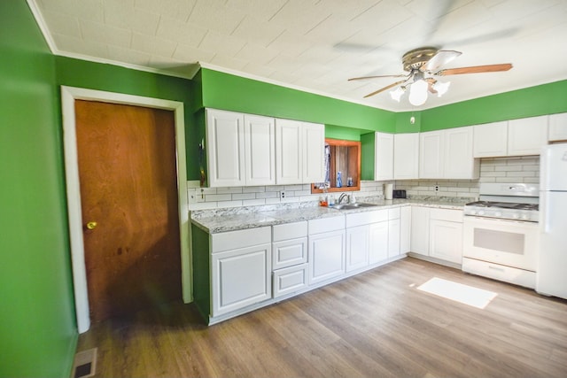 kitchen featuring a sink, white cabinetry, white appliances, light wood finished floors, and ceiling fan