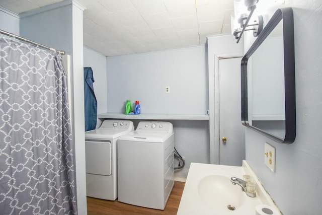 bathroom featuring independent washer and dryer, curtained shower, wood finished floors, and a sink