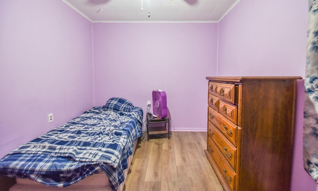 bedroom with a ceiling fan, crown molding, and light wood-style floors