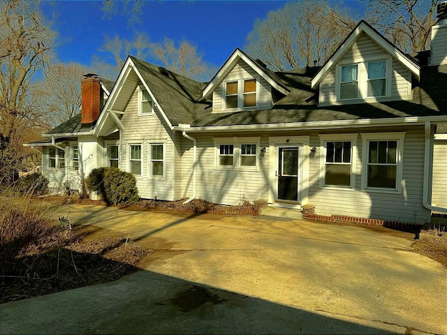 view of front of property with entry steps and a chimney