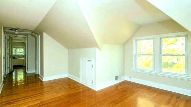 bonus room with visible vents, baseboards, wood finished floors, and vaulted ceiling