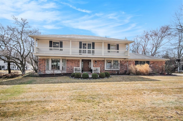 view of front of home with a porch, a balcony, brick siding, and a front lawn