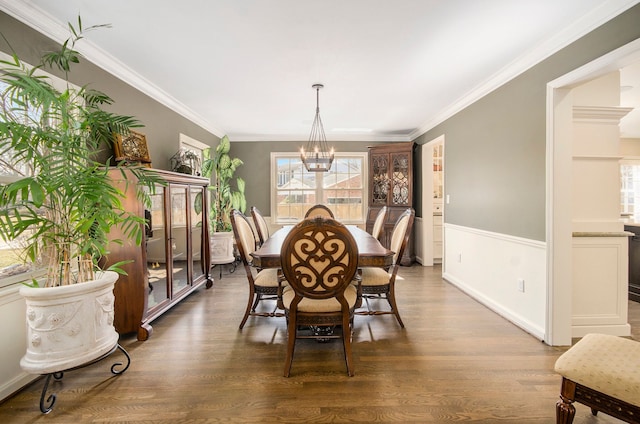 dining room featuring baseboards, crown molding, an inviting chandelier, and wood finished floors